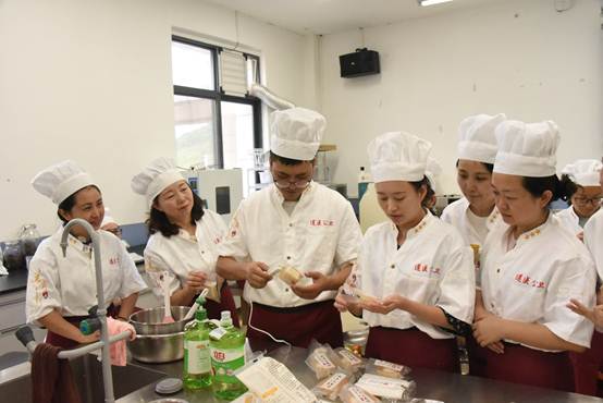 说明: 一群人在厨房里制作食物描述已自动生成